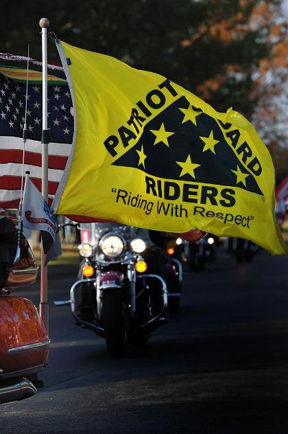 Patriot Guard Riders member riding with American flag and PGR flag