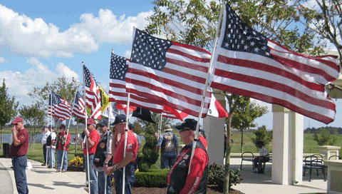 Patriot Guard members holding flags in a flag line at Houston National Cemetery